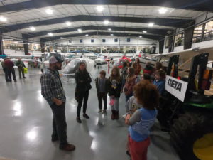 Youth standing in plane hangar.